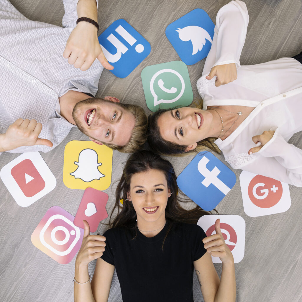 young-smiling-friend-lying-floor-with-social-media-logos-showing-thumbup-sign